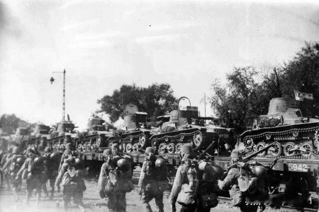 1937 年，日本士兵在天津经过一列满载日本九五轻战的火车