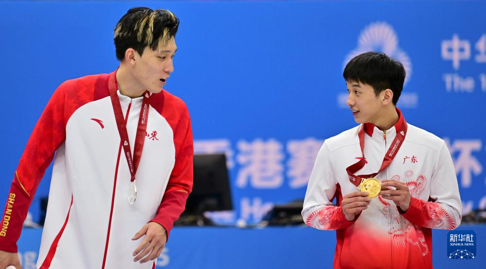      11月20日，广东队球员杨溢（右）向山东队球员曲笑宇展示自己的金牌X2