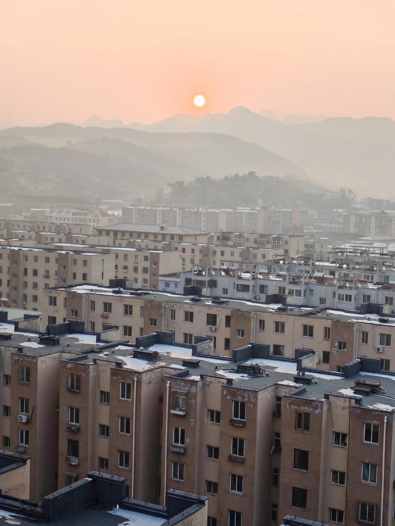 朝阳升起，天空雾蒙蒙的，太阳轮廓模糊，像被一层纱幔轻轻笼罩。世界仿佛还带着昨夜的