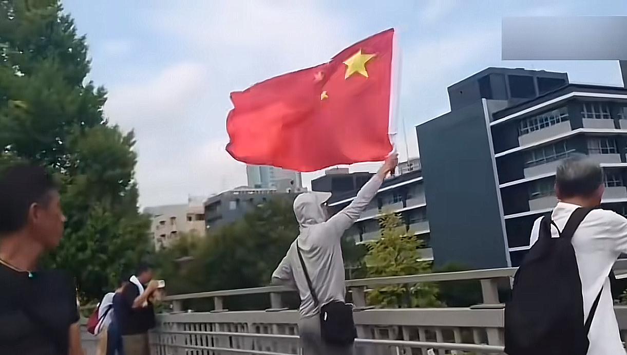 日本投降日，在那臭名昭著的靖国神厕旁，一名中国人挥舞五星红旗欢庆胜利，这画面太提