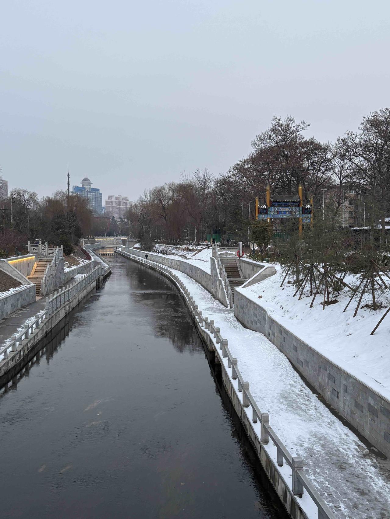 雪落中原，郑州金水河畔银装素裹，河水在静谧中缓缓流淌，别有一番韵味。