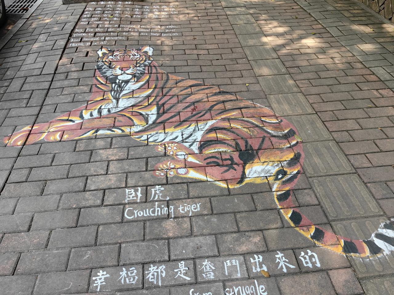 行人路上看到一只栩栩如生的老虎，还配上了中英文翻译。