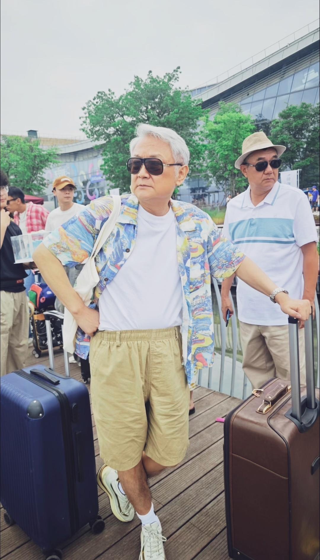 图中是欧阳奋强，满头花白短发，佩戴黑框墨镜，内搭白T恤、外搭彩色印花短袖衬衫，和