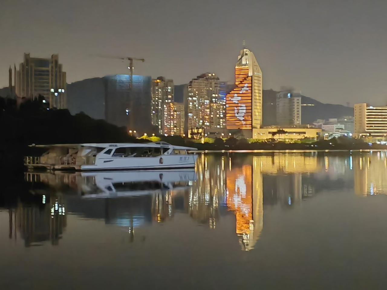 晚风、湖面、灯火，城市的夜晚被温柔的倒影揉碎成了另一个世界。

水面像块软镜子，