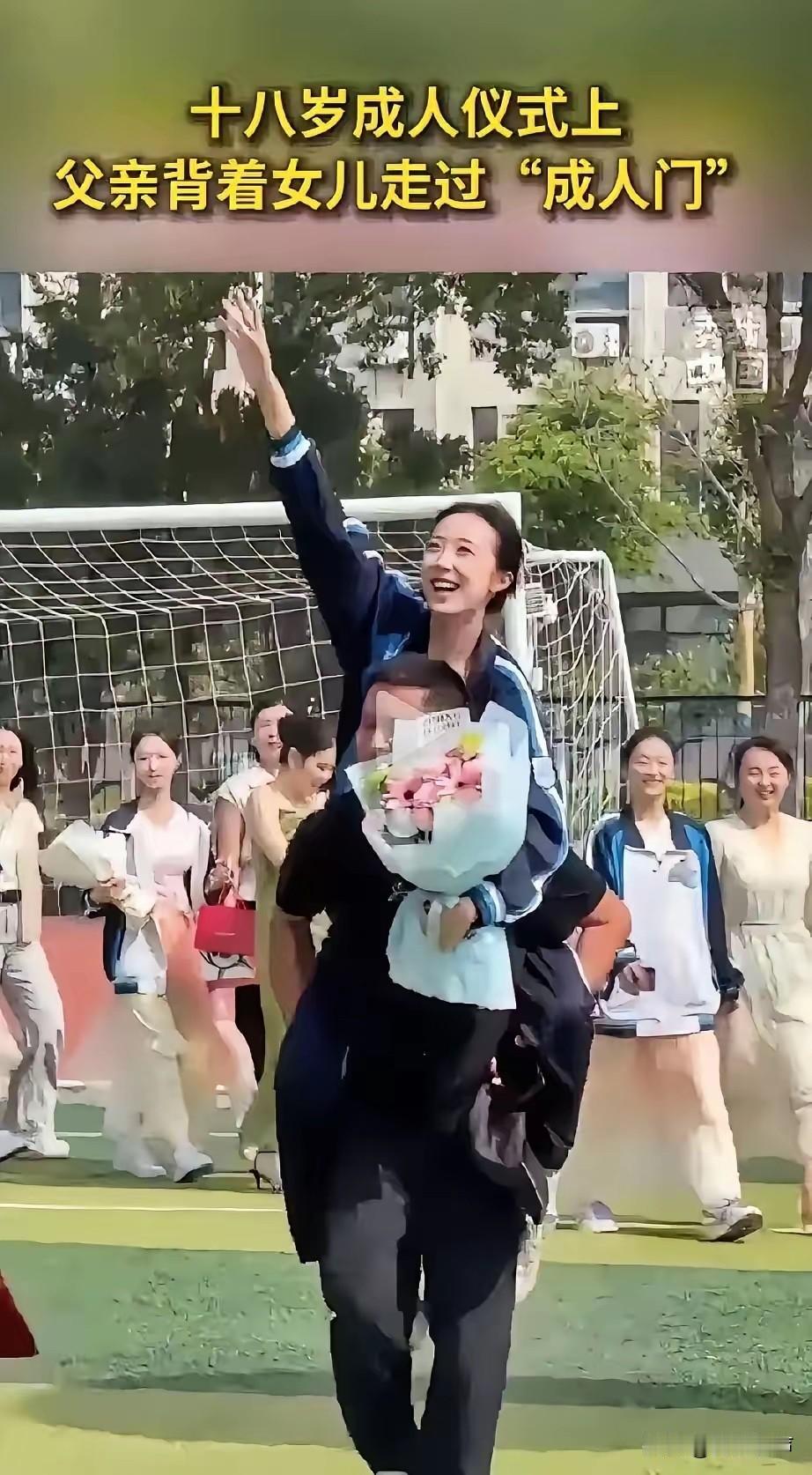 一个中学举办18岁成人仪式，仪式现场，一位父亲稳稳背着女儿缓步走过成人门，女儿手