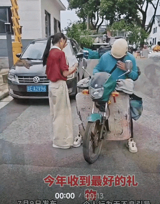 一快递员给女生送来高考录取通知书，女生下来拿时，为分享喜悦和感谢送件，不仅满脸笑