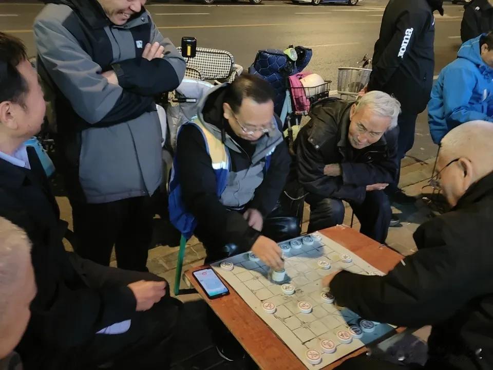 街灯映棋盘，落子声清脆，老友对弈忘归家