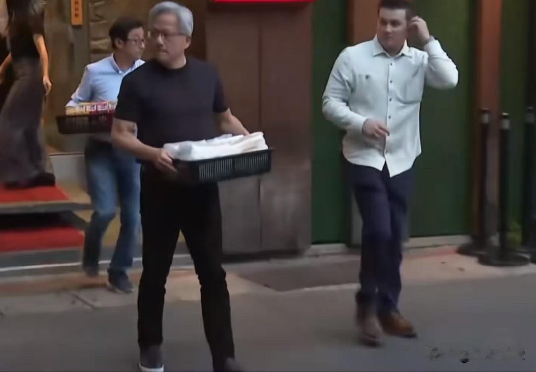 英伟达老板黄仁勋自己捧着一筐食物从饭店里走出来，服务员冲上去想帮他拿，他不肯，然