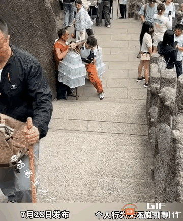 一名男子独自爬黄山，偶遇挑夫大叔休息，主动上前帮忙挑一程，帅小伙这个暖心举动，打