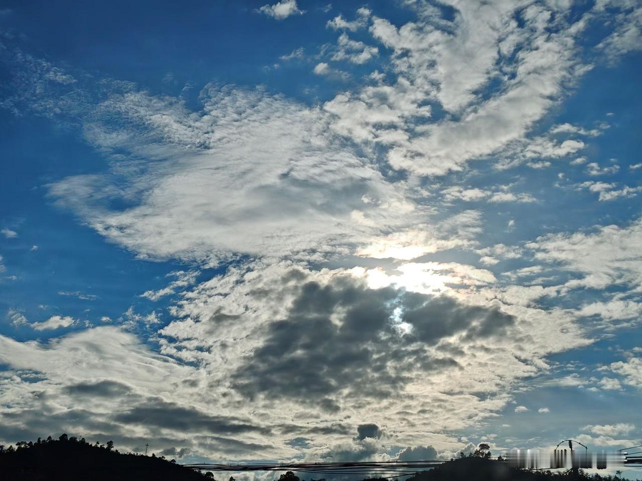 今天出门抬眼，被这片天攥住脚步。

像有人把棉花撕得碎碎的，揉在靛蓝的布上——厚