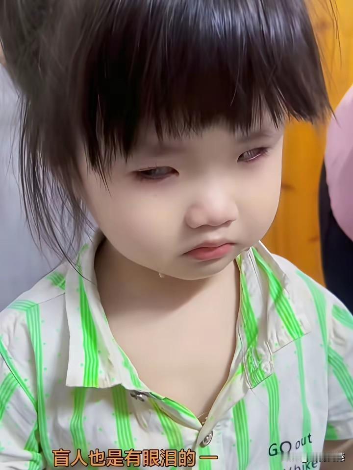 孩子的脸上也有泪水，虽然她的眼睛看不到光明，对这样的孩子，我们更应该加倍的呵护，
