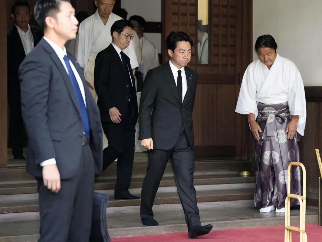 一个首相，在停车场里，朝神社方向鞠躬。然后转身去参加政府主办的追悼仪式。
一边是