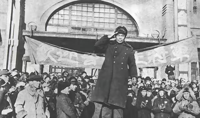 人群中一个人正在敬礼。有个难题，问一下历史老师，这是哪位人物在敬礼🫡，没看出来