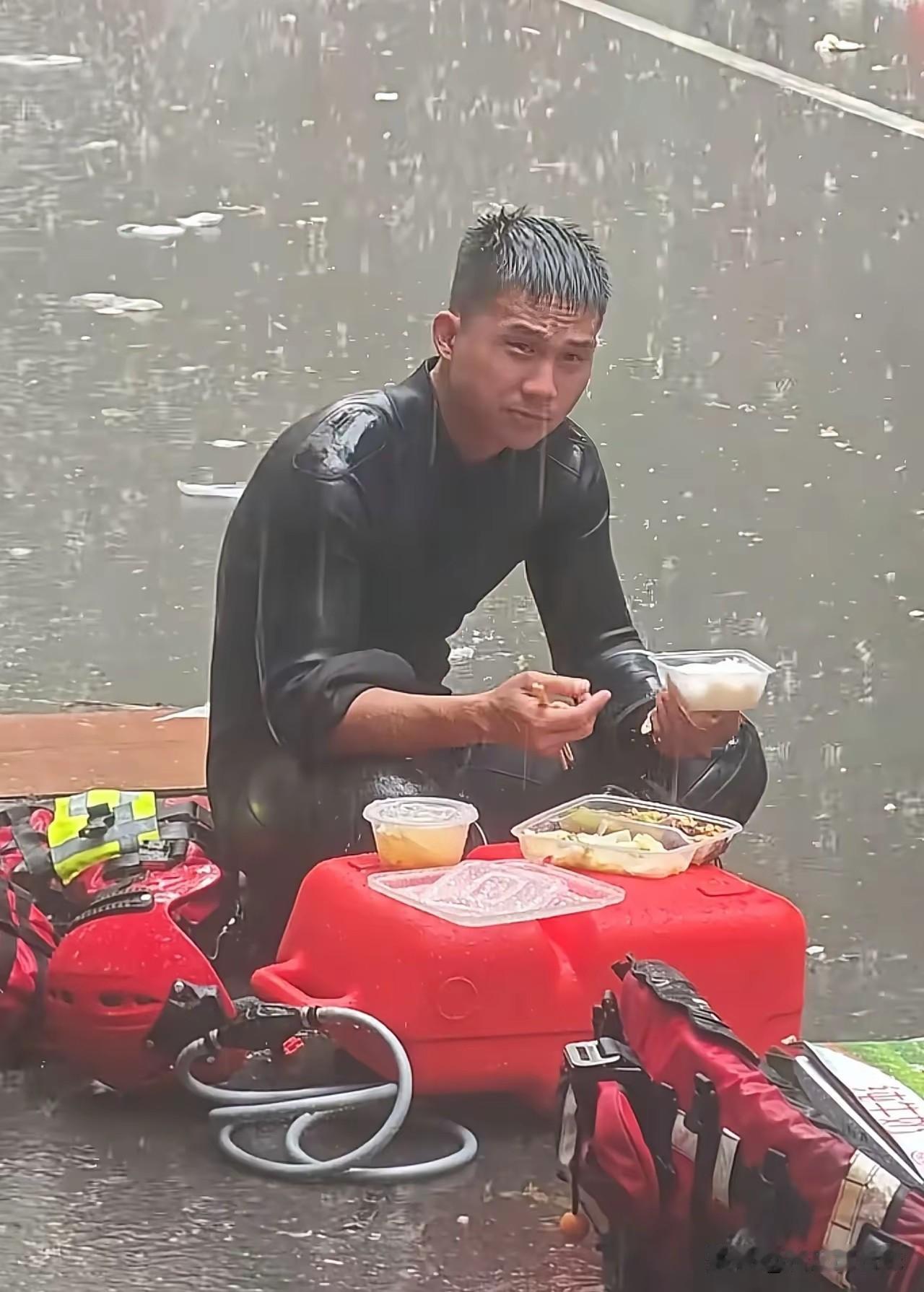 “泪目了”消防战士盘腿坐在地上吃饭，老天爷偏在这个时候又开始肆虐，雨又哗啦啦地下