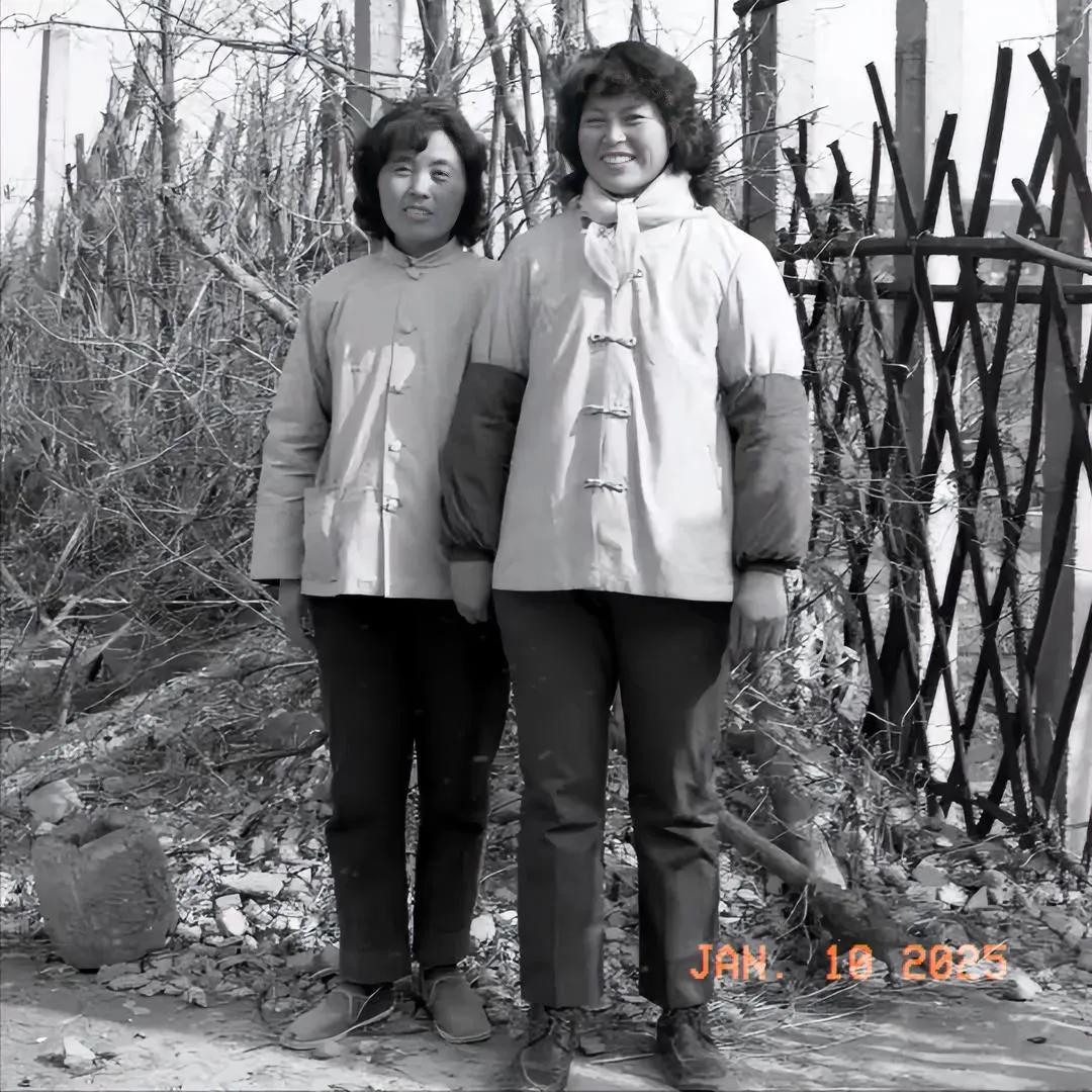 这是一对亲姐妹在自家庭院外的合影，拍摄时间为80年代，照片中别的没记住，那副套袖