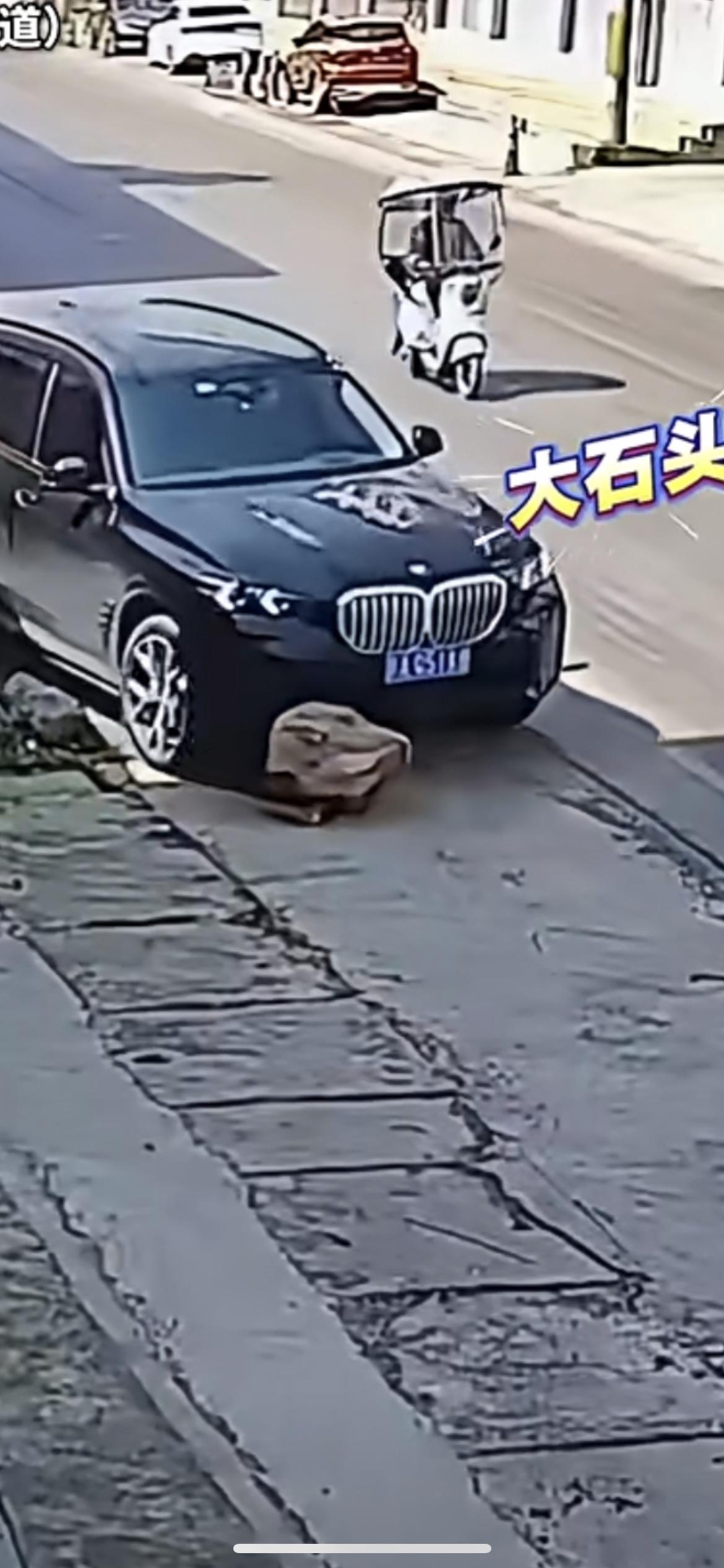 4月15日浙江，男子开宝马车没发现大石头，顶着石头往前开 直到车头被顶起，网友：