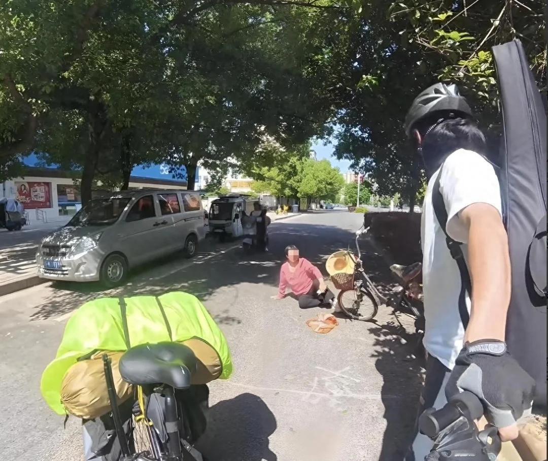 江西抚州。
小伙骑着摩托，车头支着手机拍短视频。前方大妈突然摔倒，小伙赶紧去扶，