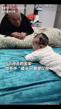 5个月大的宝宝火了！近日，河南周口，一老人趴在床边逗孙子玩，奶奶在一旁说：“给爷