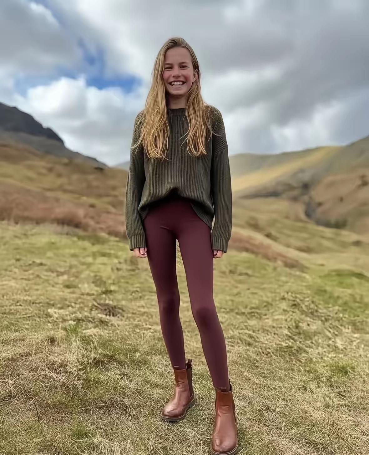 夏洛特小公主的最新照片，照片中的公主笑容灿烂，身穿墨绿色毛衣和酒红色打底裤。夏洛