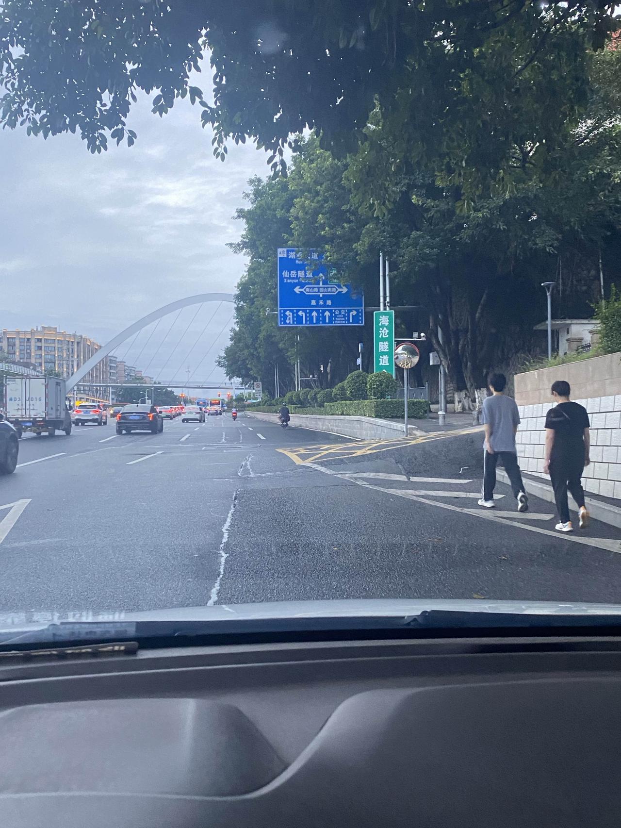 在一条双向单车道上，一辆白色汽车旁若无人地慢悠悠行驶着。后面的货车急着送货，轻轻