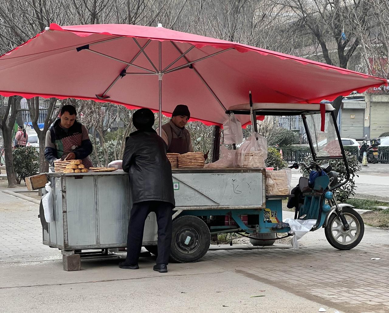 现在摆地摊儿的比门面店赚钱。
早上路过一个烤馕摊，4块钱买了一个馕，我问那个维族