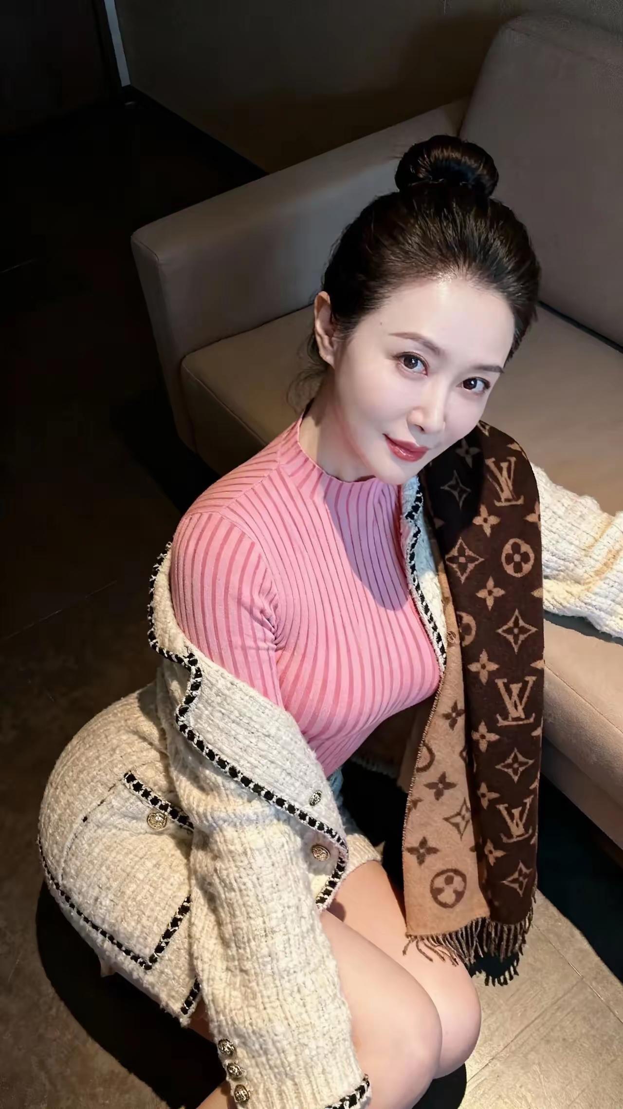 丸子头利落挽起，俏气得刚好。
眉眼弯出柔润笑意，粉条纹内搭衬得气色温软。
小香风