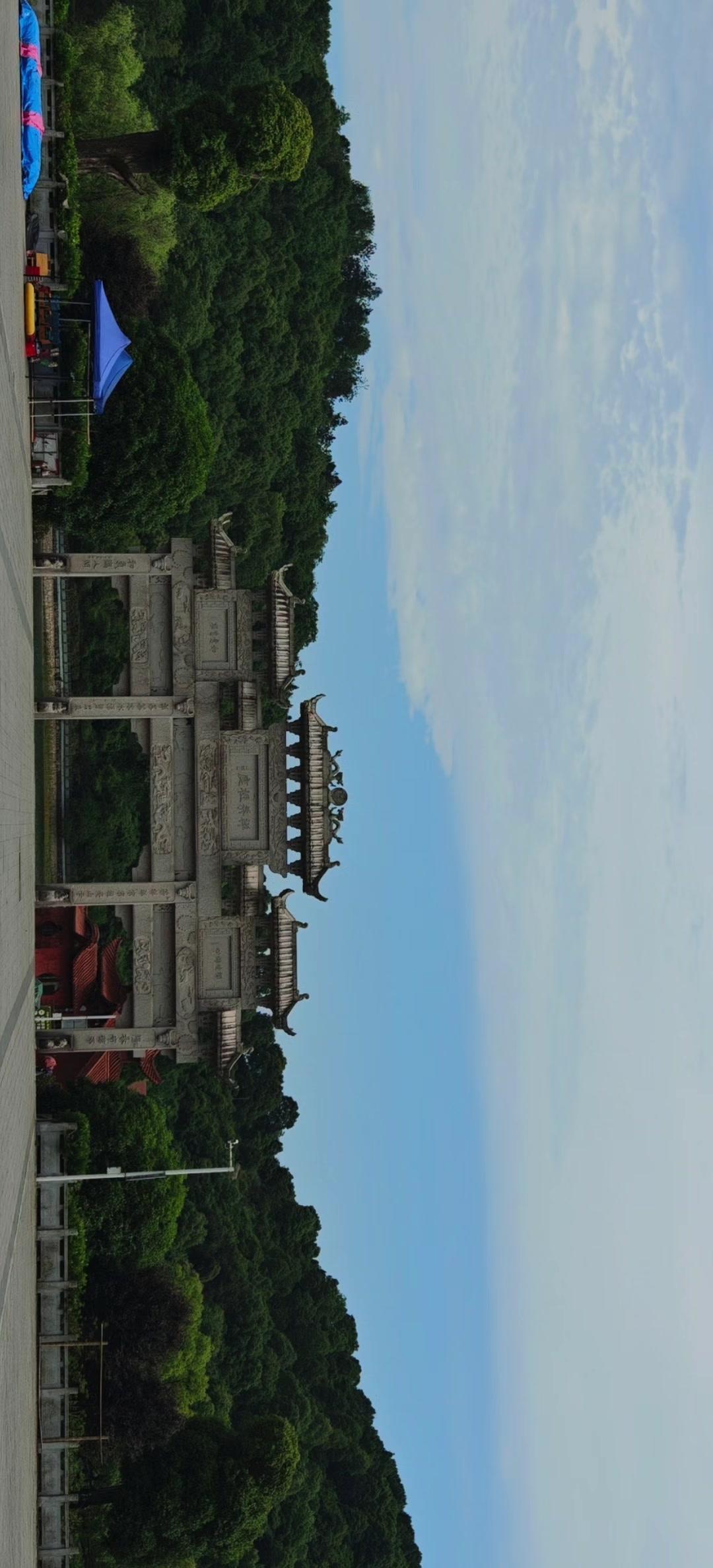 夹山的禅茶祖庭牌坊下，抬头是澄澈蓝天，身后是葱郁青山。石坊上的题字，诉说着"茶禅