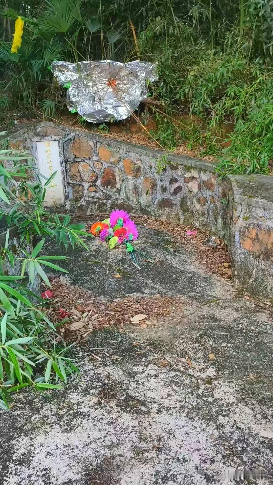 这是位于湖南湘潭乌石峰下的彭德怀元帅母亲周氏之墓，墓碑朴素，由石块砌成，墓前摆放