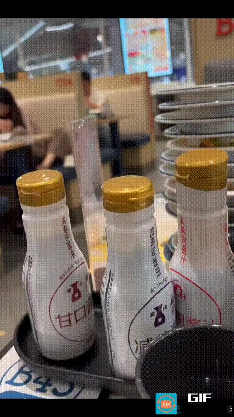 江苏扬州，一家寿司店里，一对正在用餐的母女，女儿脱掉鞋袜将脚搭在餐桌上，母亲赤着