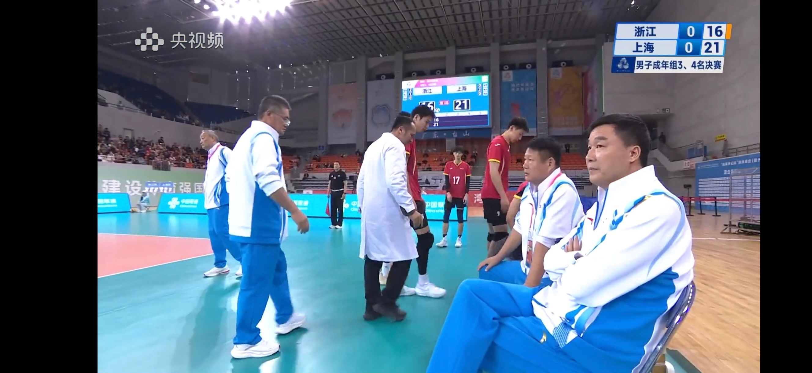 教练组就这么淡定的坐着，悠闲地翘着二郎腿 