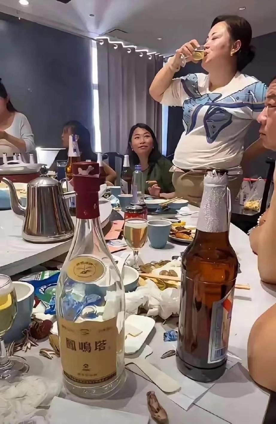 饭局上这位姐姐举杯喝酒的样子太豪迈了，一桌白酒啤酒摆满桌面，肚子都喝得鼓起来了。
