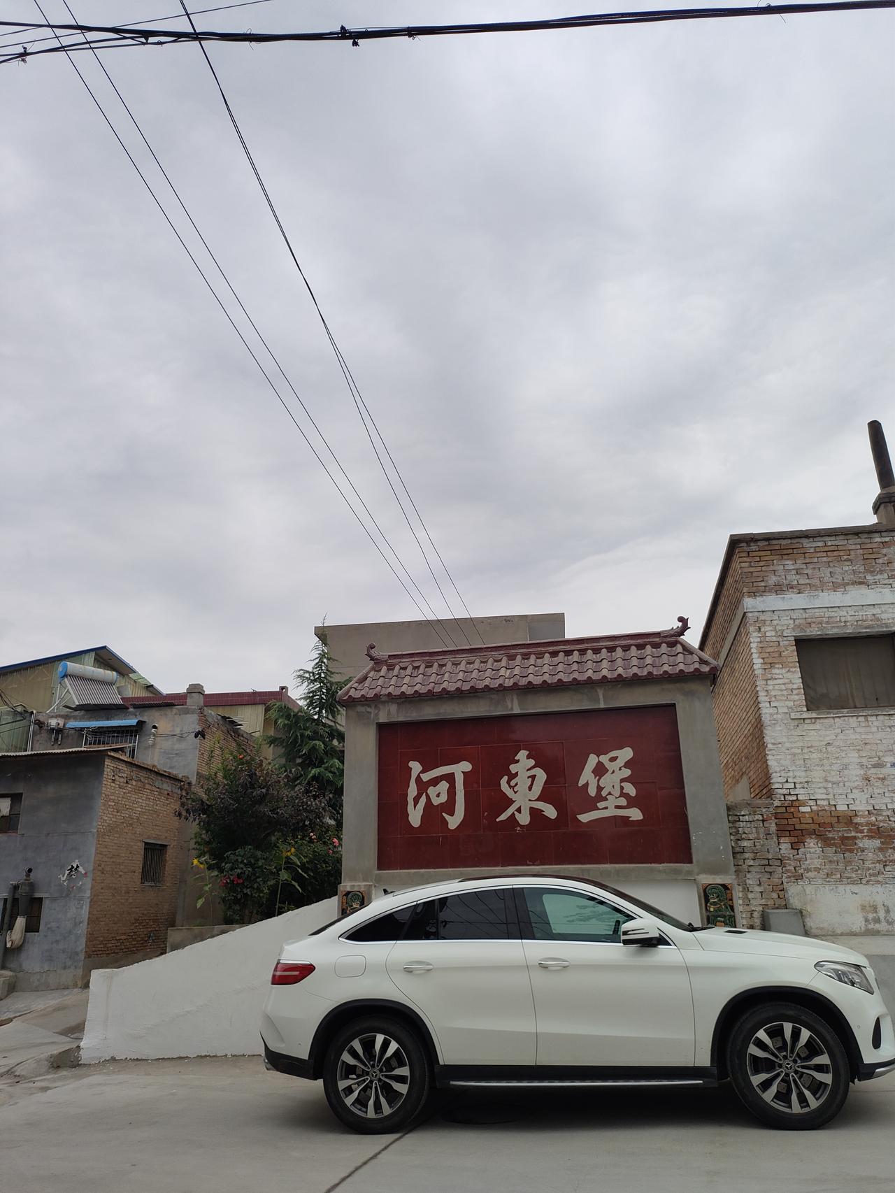 晒图笔记大赛走进河东堡，灰云漫过村落上空，老杨树撑开层层绿荫，小巷两侧老屋错落，