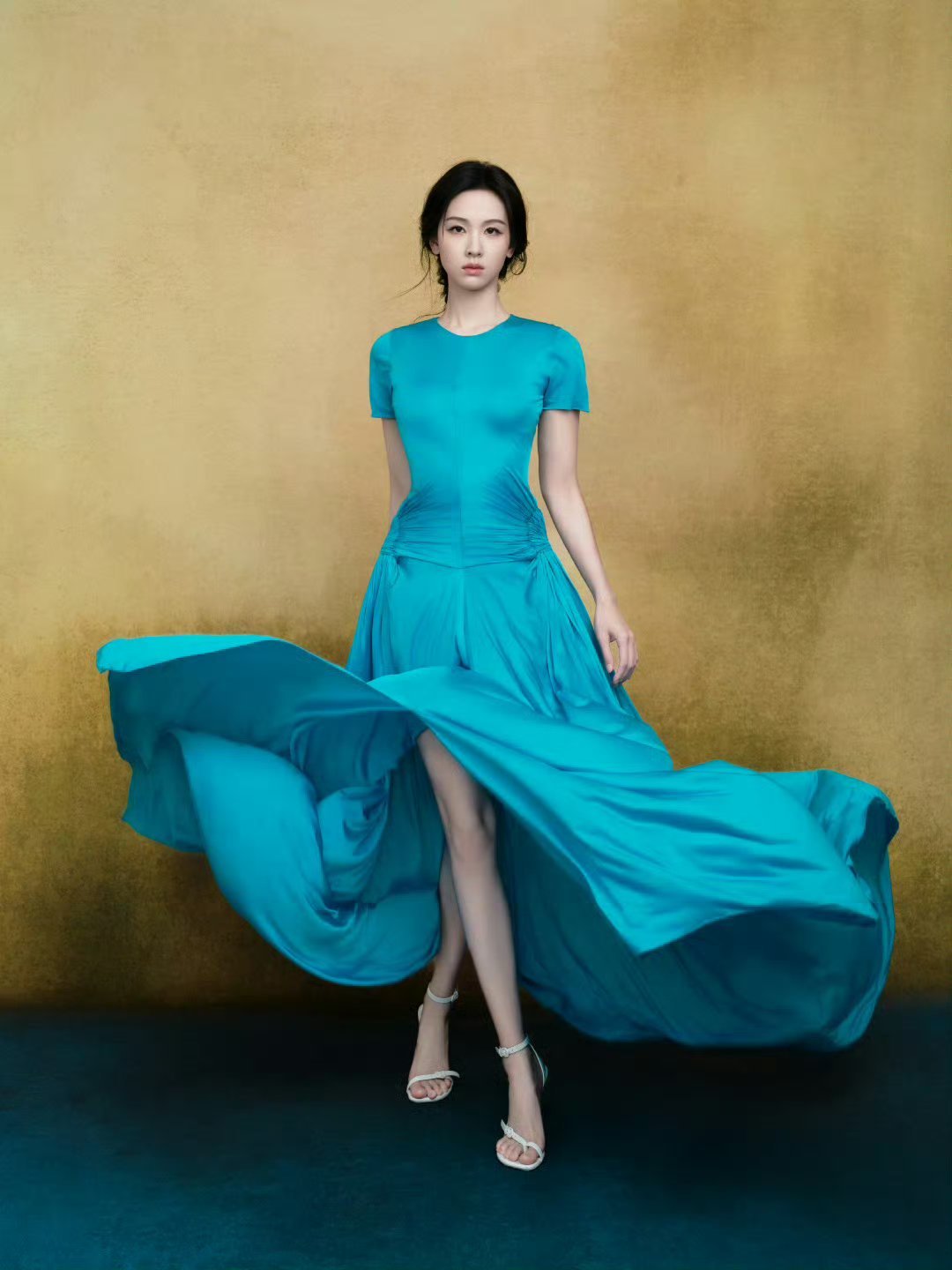 这身幽蓝长裙格外衬她的肤色，低头整理手包时，颈后露出的一小片皮肤白得透光。路过花