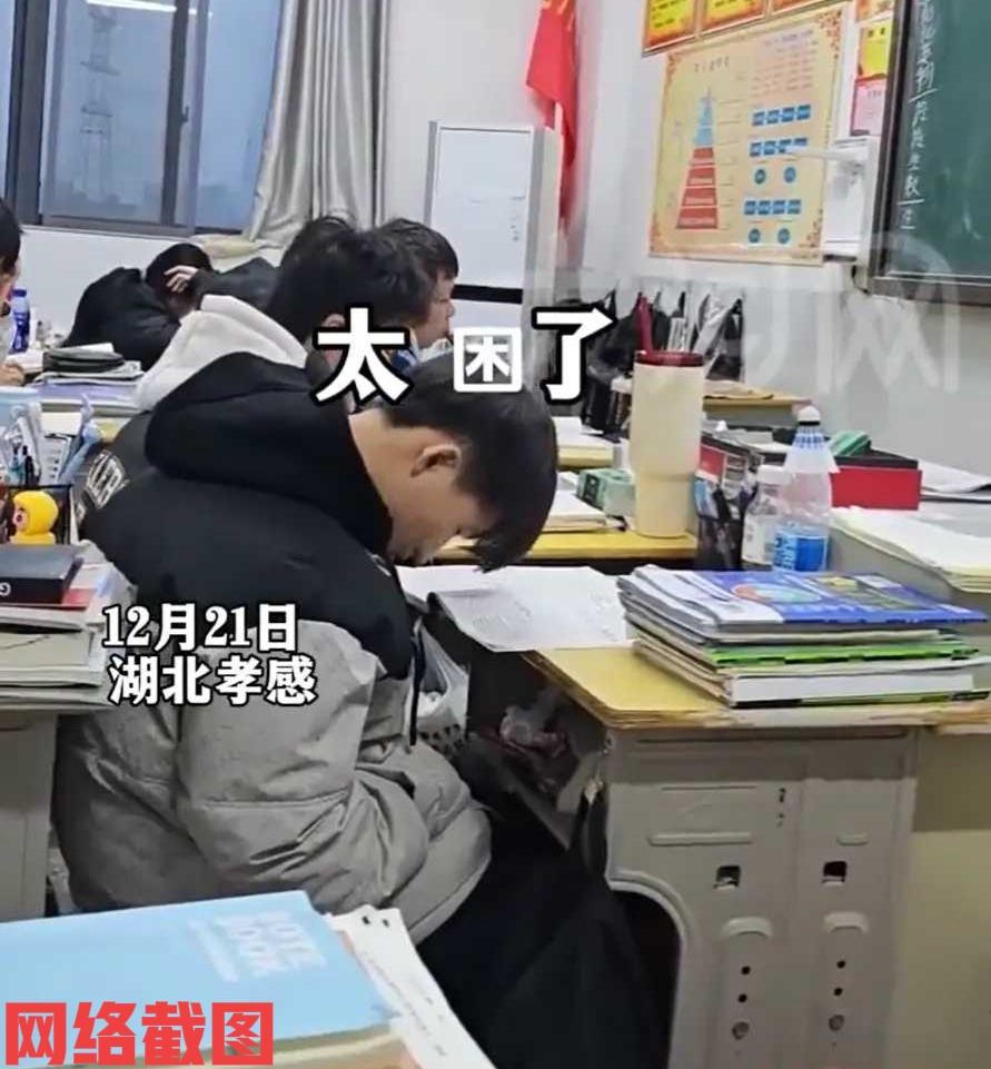 湖北孝感有学校高中班级上早读。

可是第一排有男生应该太困，感觉到睡眠不足，而不