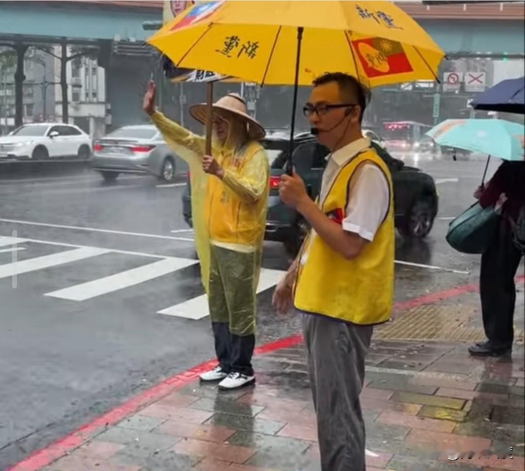 风雨交加中，游智彬不忘孤零零的站在街头向行人拜票！每天如此，从不间断，没有政治献