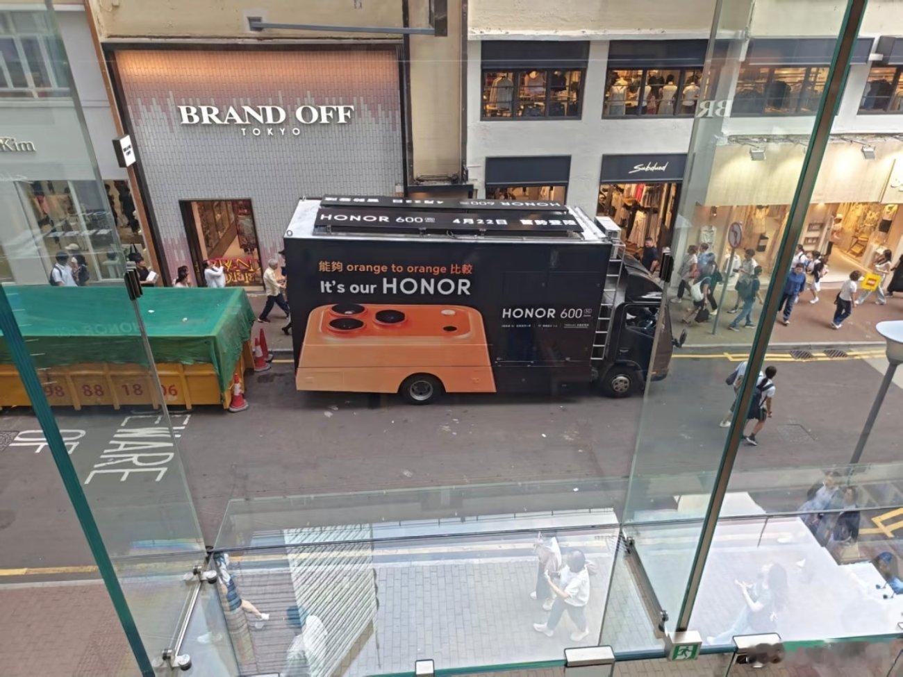 前几天发生在香港的一件有意思的事情，荣耀开着一辆车去苹果门店“踢馆”，在车上印着