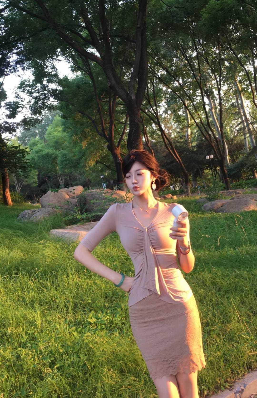傍晚公园的柔光太适合浅色系穿搭，裸粉绑带上衣自带温柔滤镜，V领设计衬得脖颈线条纤