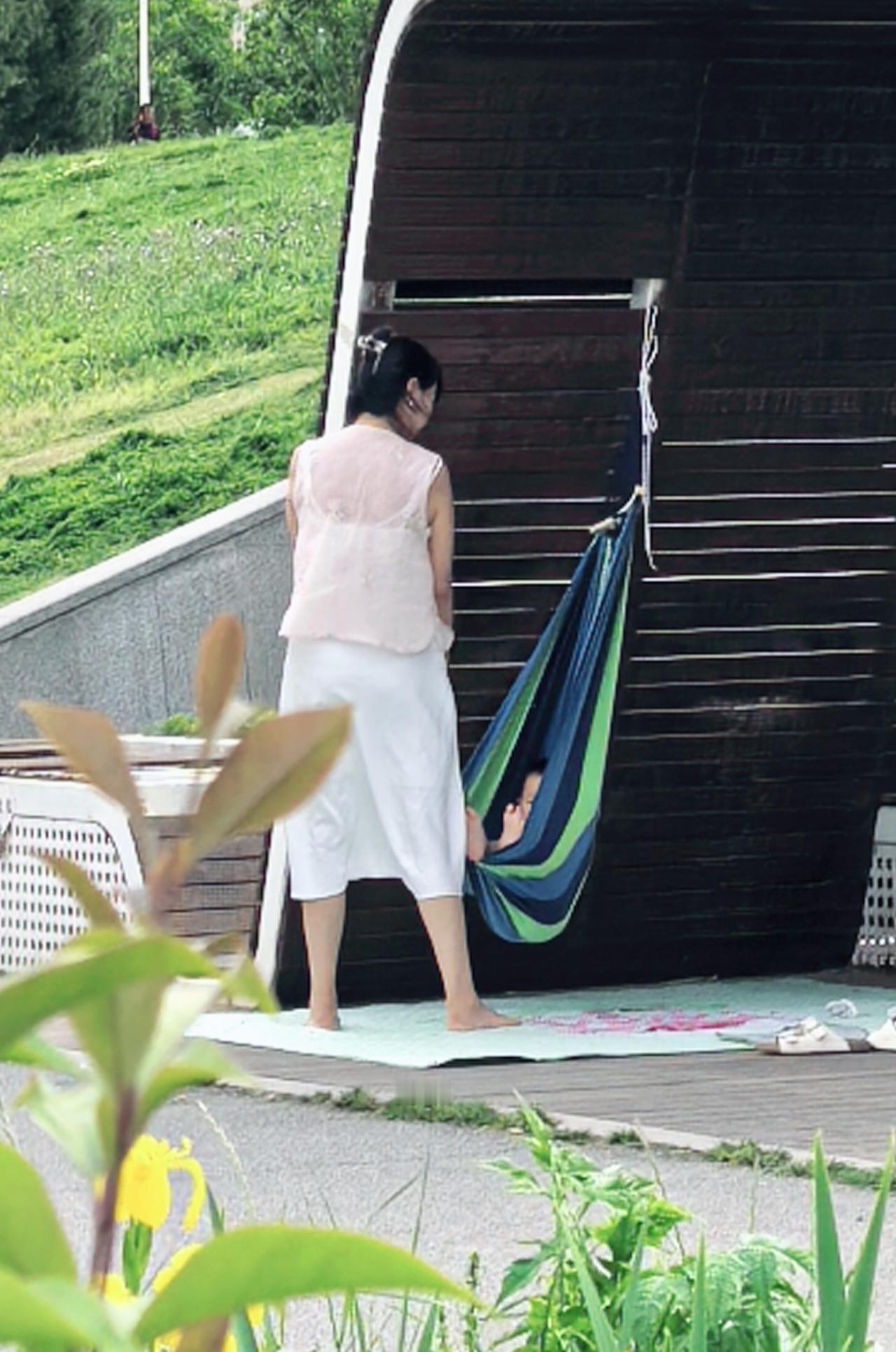 吊床里的春天，是妈妈摇晃出来的童话呀。
木质的廊檐下，吊床轻轻晃 ，
妈妈踮着脚