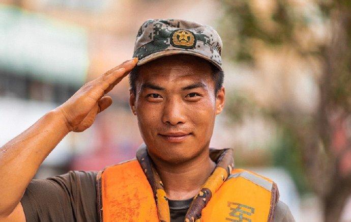 看到两个老人因电梯事故跌倒，三名人民子弟兵及时跨过中间扶手，将他们搀扶起来，令人