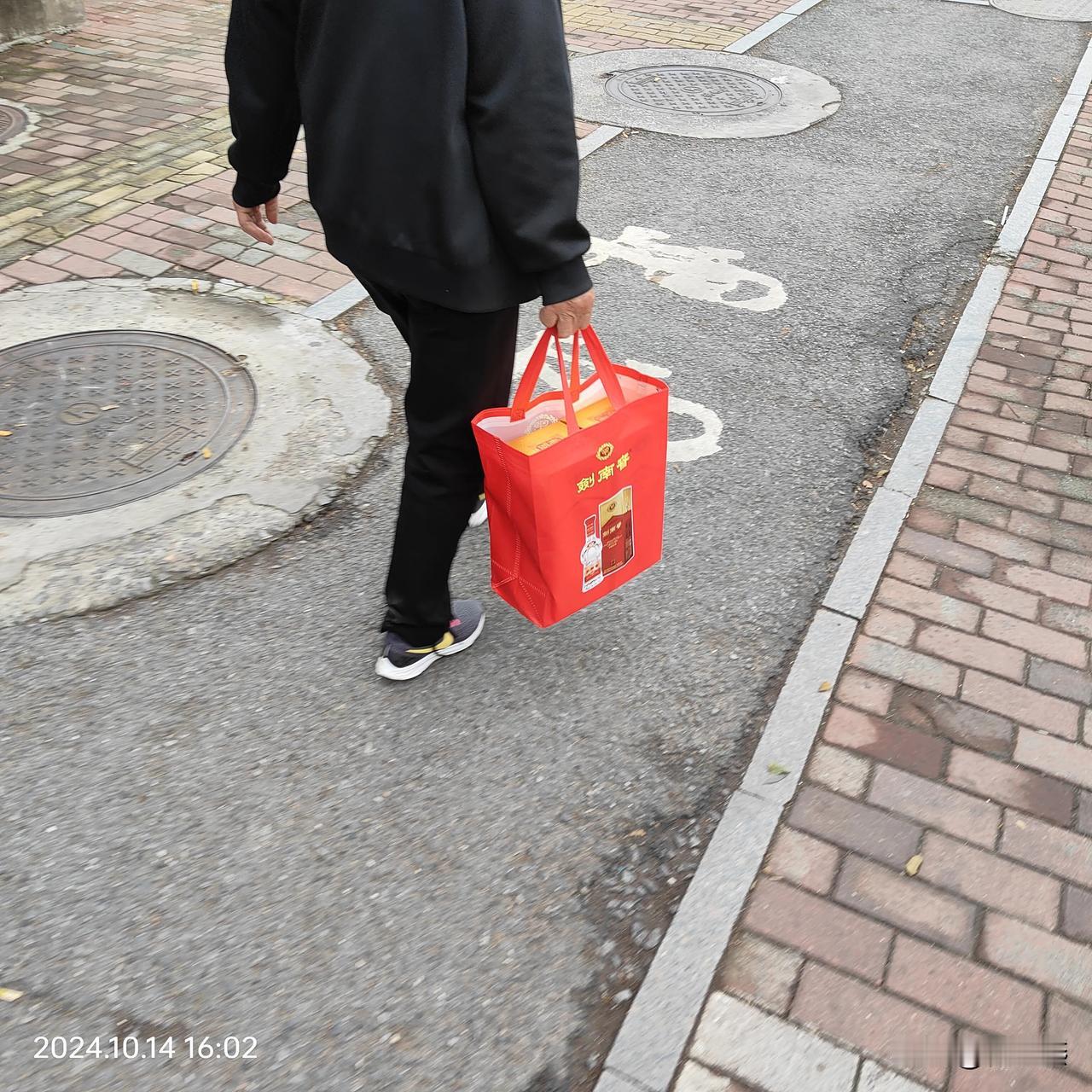 哎呀，人不可貌相啊。
这不起眼的老太太，手里提的可是剑南春啊。

能喝得起剑南春