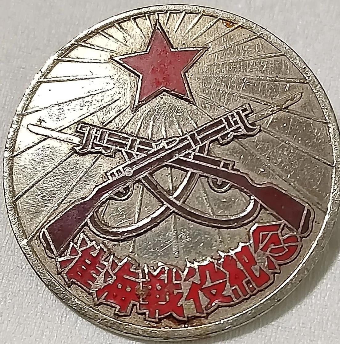 一枚刻有枪和星星的淮海战役纪念币。谁家还有，拿出来晒晒。