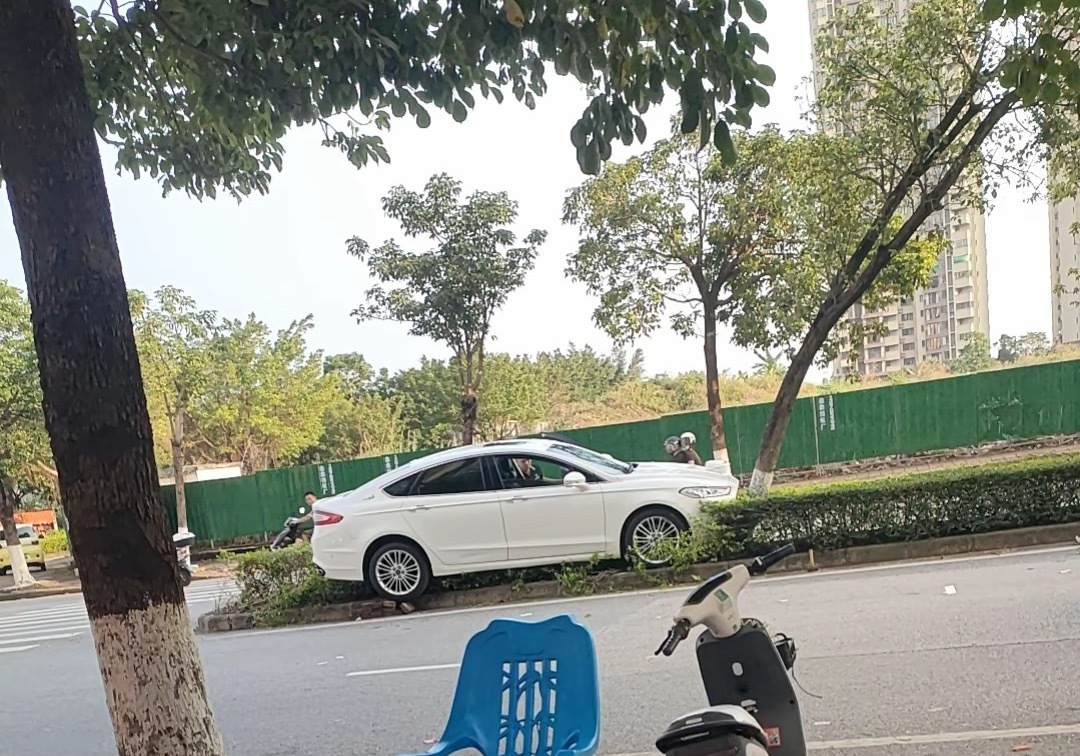 【钦州小车冲上绿化带男子用千斤顶救援】4月28日，网友爆料称：广西钦州一辆白色小