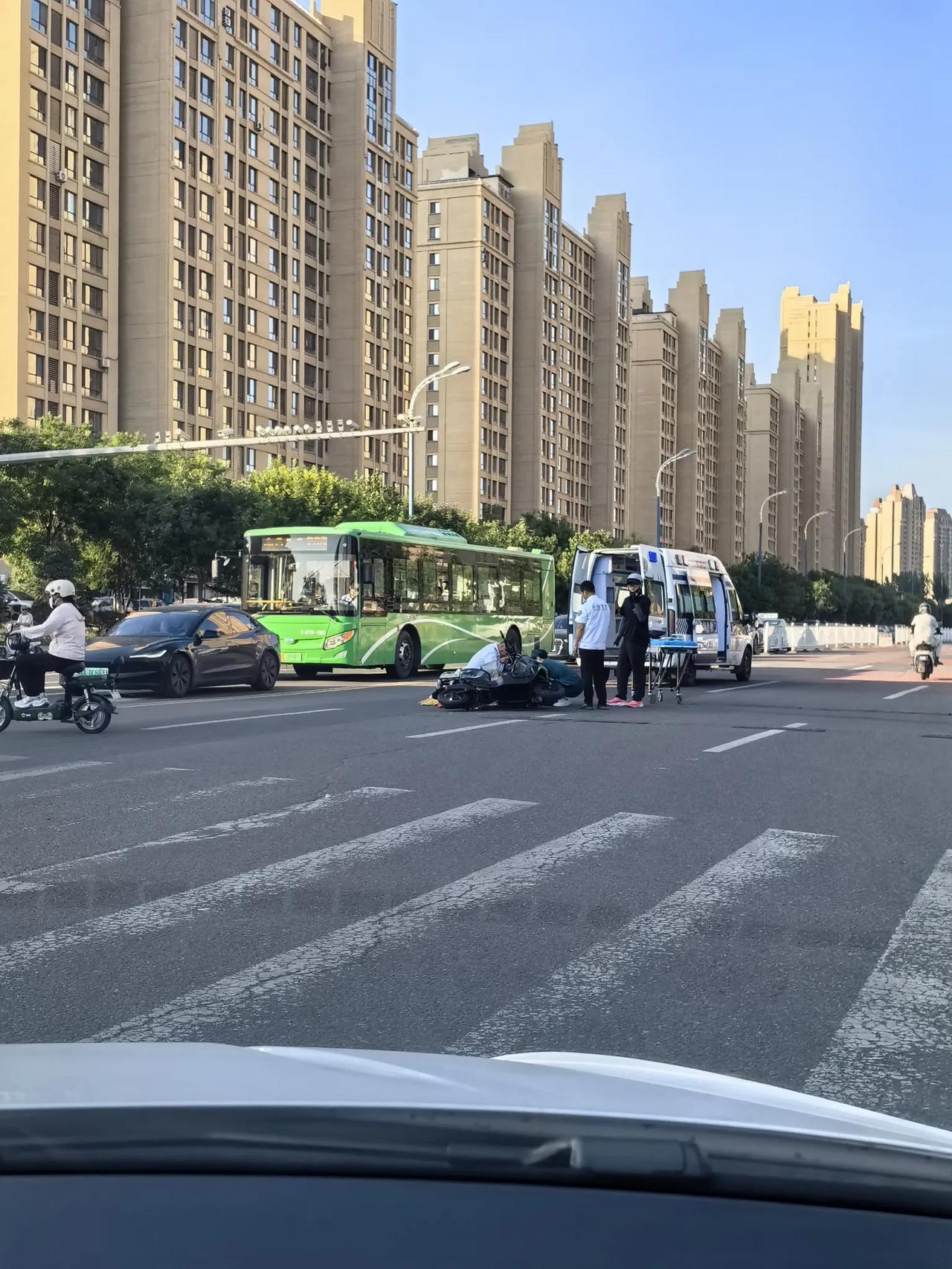 昨天中午，在呼和浩特市赛罕区的一个十字路口，一位骑电动车的人躺在路上，医护人员正