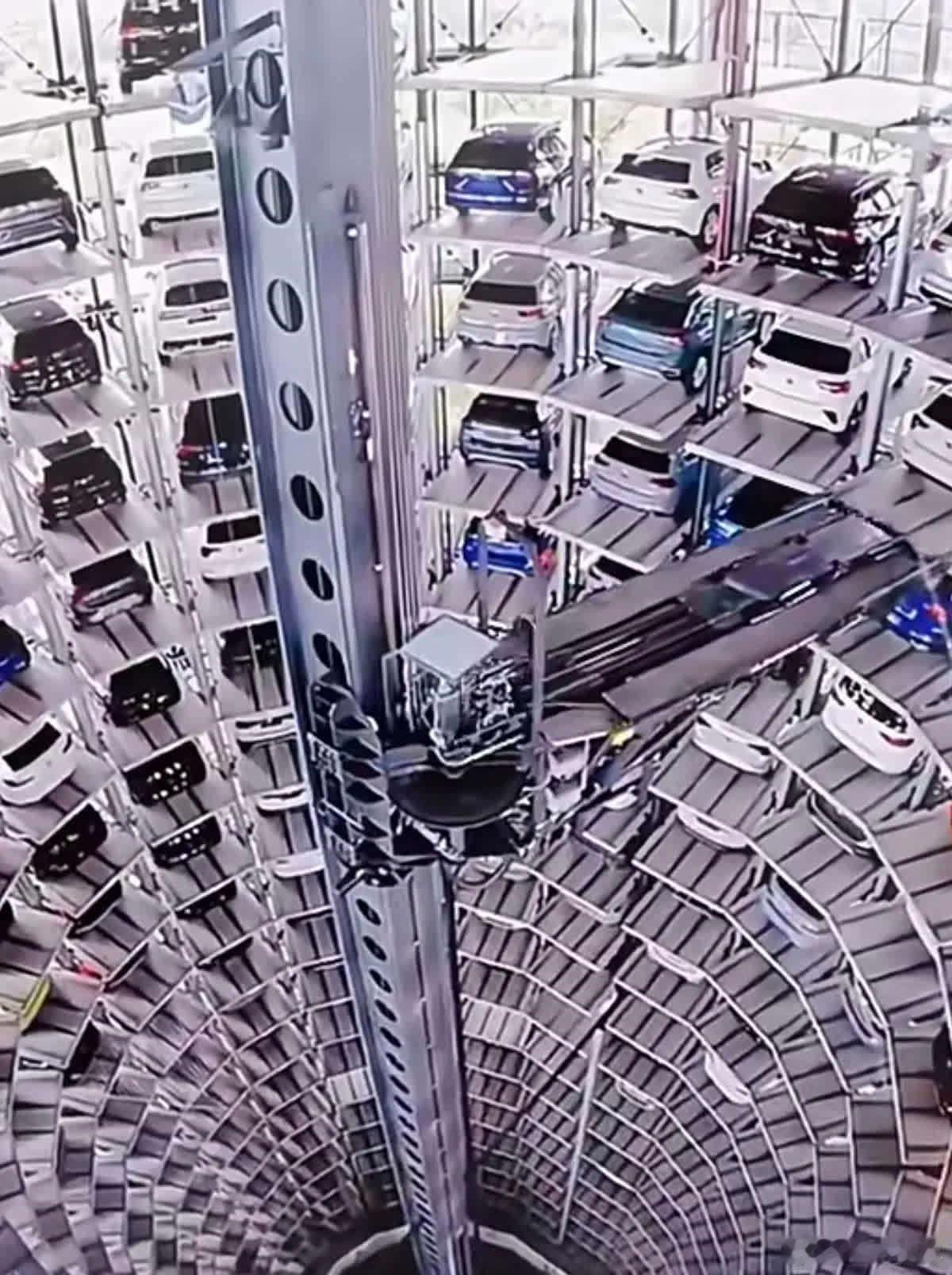 停车场实拍图，活脱脱一个“钢铁蜂巢”！密密麻麻的车子像叠罗汉似的摞在铁架子上，全