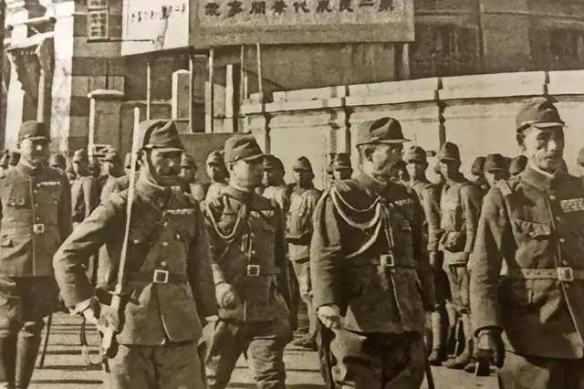 这是一群日本侵略者的军官，走在中国街头上，一个个趾高气扬，耀武扬威，他们满手沾满