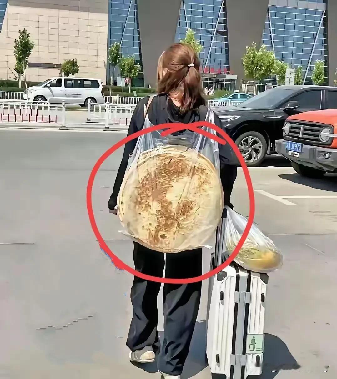 女大学生背着干粮找工作，这么大的饼估计够吃几天吧！