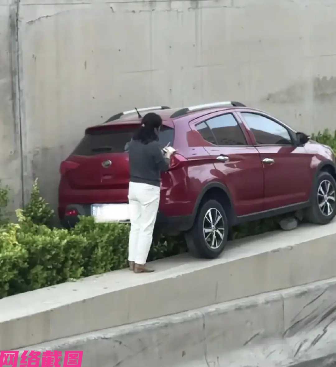 山西太原看有位女司机，这次不知怎么竟然把自己的红色小车，开到路旁高台阶上，女子一