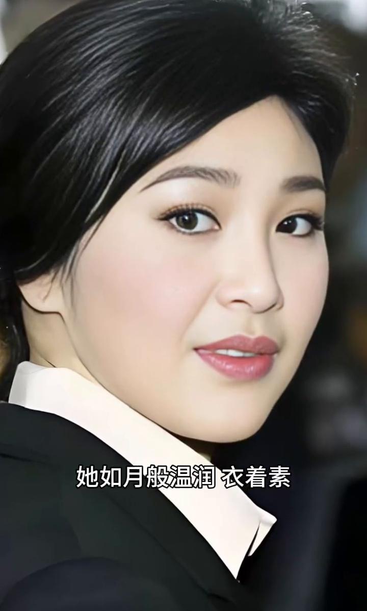 她如月般温润，衣着素雅沉静，妆容淡雅合宜，一笑之间优雅悄然流露，风采自然而动人。