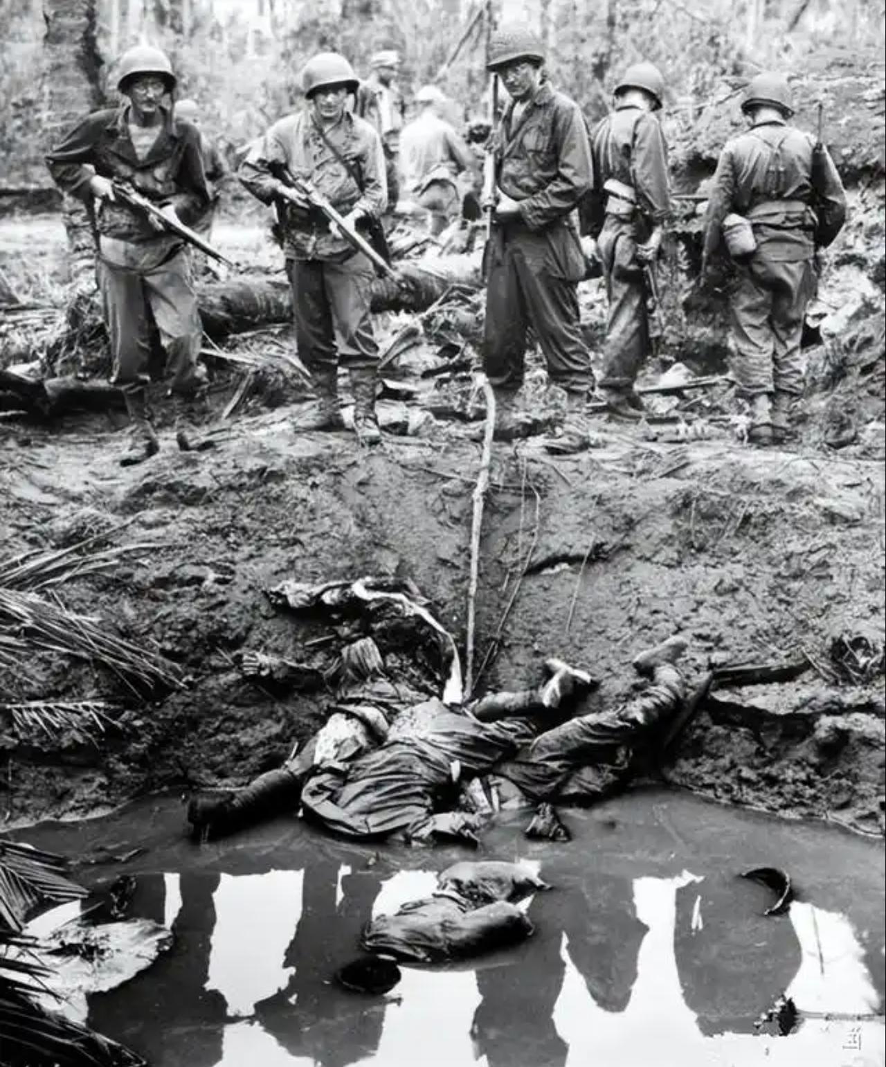 这张黑白老照片记录了第二次世界大战太平洋战场的残酷战斗场景。
 
画面里几名美军