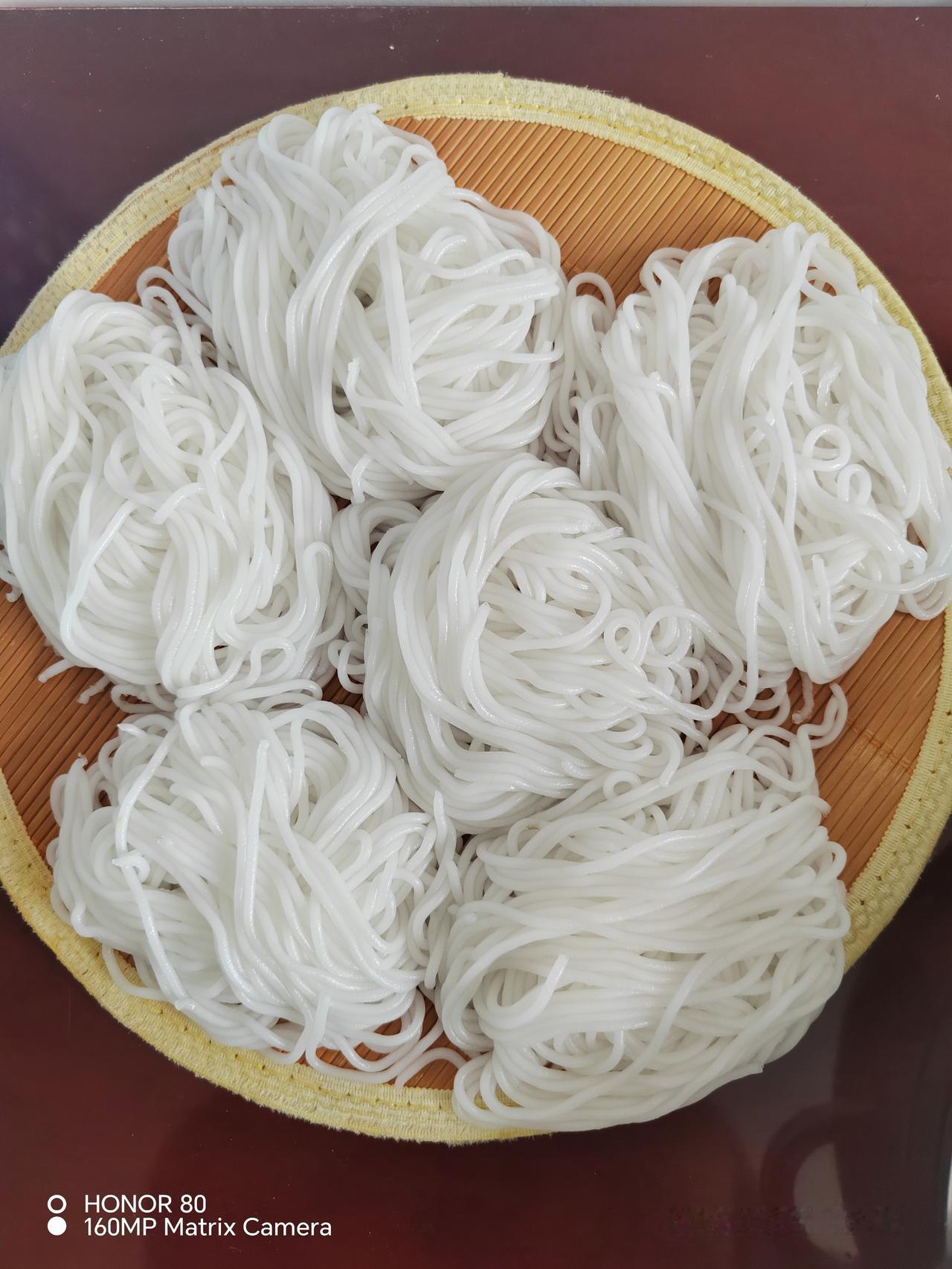 今天新压出来的土豆鲜粉，一团团盘好放在盖帘上。
鲜土豆粉条和干粉口感差别很大，更